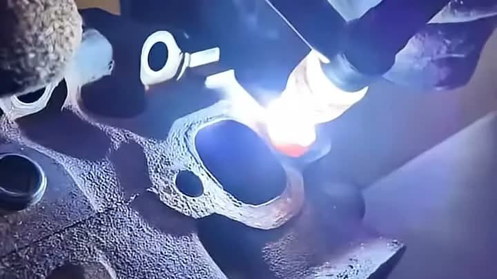 Svetsarbete på topplock i gjutjärn hos Meksta, gjutgodset värms upp inför reparation